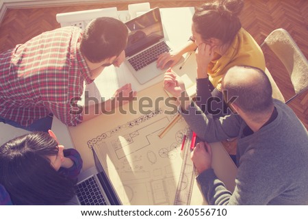 Young group of people/architects discussing business plans.