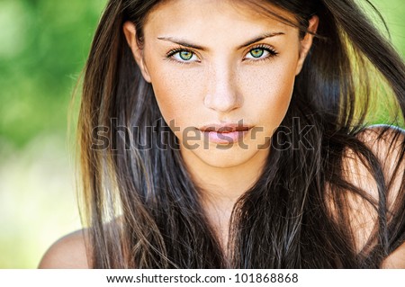 Portrait close up of young beautiful woman, on green background summer nature.