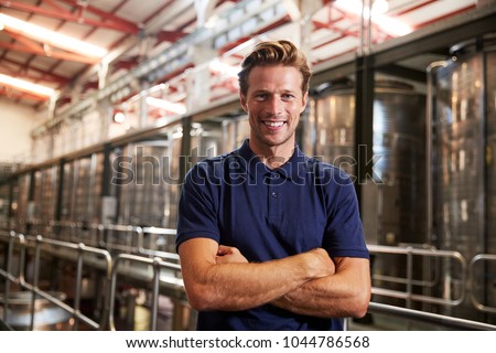 Portrait of a young white man working at a wine factory
