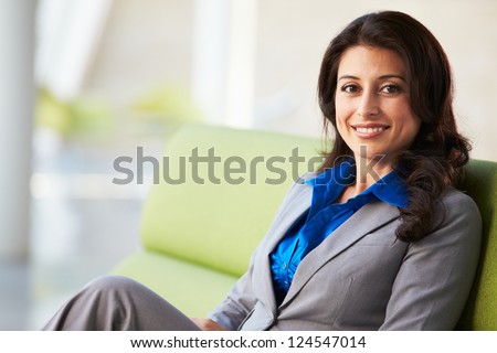 Portrait Of Businesswoman Sitting On Sofa In Modern Office