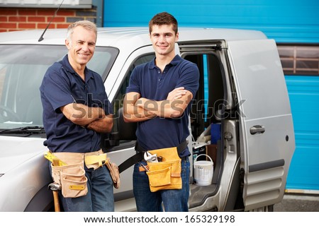 Workers In Family Business Standing Next To Van