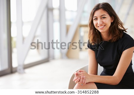 Portrait of young mixed race Asian businesswoman sitting