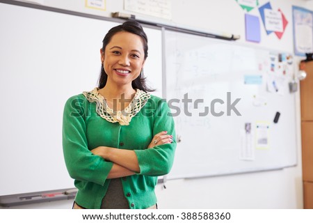 Portrait of confident Asian female teacher in classroom