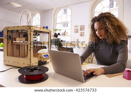 Female Designer Working With 3D Printer In Design Studio