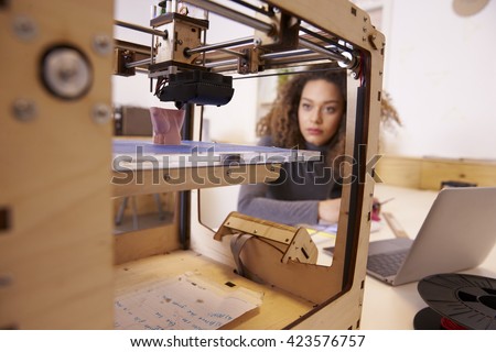 Female Designer Working With 3D Printer In Design Studio