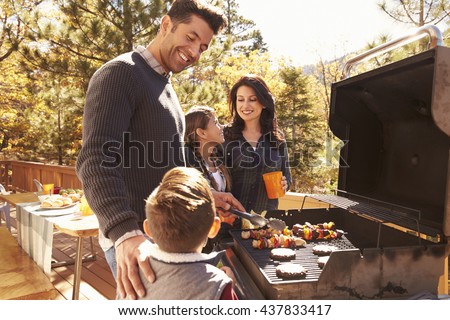 Family barbecuing on a deck in the forest