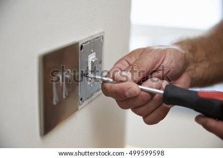Close Up Of Electrician Repairing Domestic Light Switch