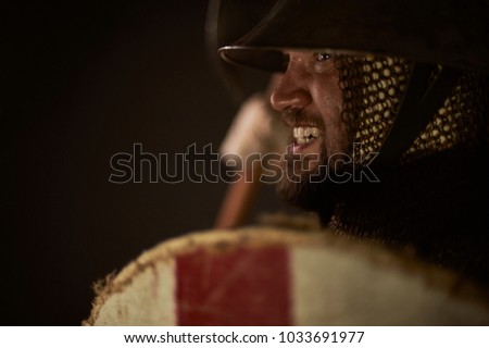 Medieval infantry man charging for attack. Historical re-enactment scene with authentic clothing and props