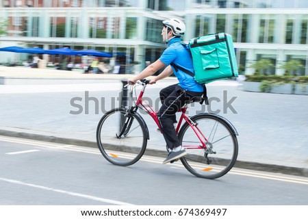 Courier On Bicycle Delivering Food In City