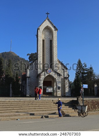 Sapa, Vietnam - Jan 15, 2015: Cleaner cleaning the side walk on the sidewalk of the square in front of the Catholic Holy Rosary church in Sapa town, Lao Cai province, Vietnam.