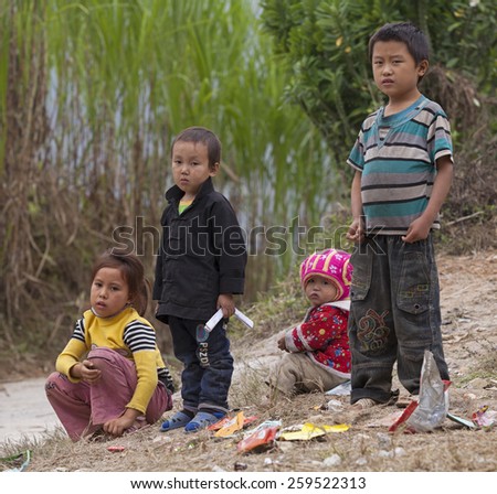 HA GIANG, VIETNAM - NOV 14, 2014: Close up photo of unidentified poor Hmong child playing on the dirty ground in Dong Van rocky plateau. Dong Van rocky plateau is a well known geopark.