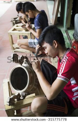 Bac Ninh, Vietnam - Sep 12, 2015: Junior craftsmen making copper handicraft products in traditional way (hand work) in Dai Bai village. Junior people are major labors in traditional works in Vietnam.