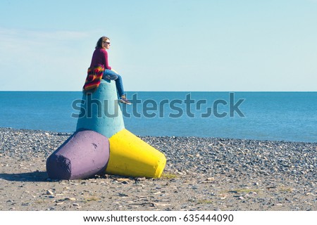 https://thumb1.shutterstock.com/display_pic_with_logo/1962149/635444090/stock-photo-woman-sitting-on-a-concrete-tetrapod-on-the-beach-635444090.jpg