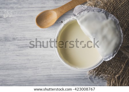 Natural yogurt on the white wooden table top view