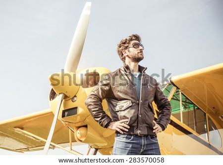 aviator posing before flight with his aircraft. concept about airplanes,pilots and people