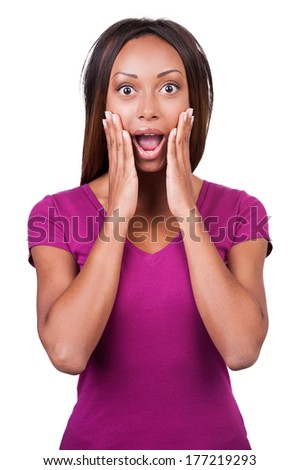What a surprise! Surprised young African woman holding her head in hands while standing isolated on white 