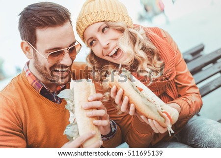 stock-photo-happy-young-couple-they-are-laughing-and-eating-sandwich-and-having-a-great-time-511695139.jpg