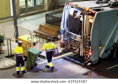 sweeper truck vehicle and cleaner workers at night