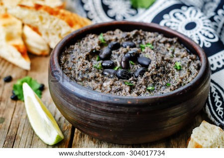 black beans hummus on a dark wood background. the toning. selective focus