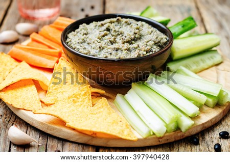 black bean dip with vegetables and corn chips. toning. selective focus