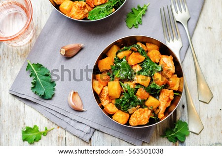 Kale sweet potato chicken stew on a wood background. toning. selective focus