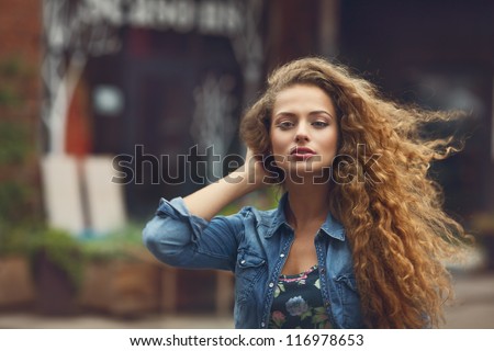 Beautiful young Caucasian girl with curly hair outdoors