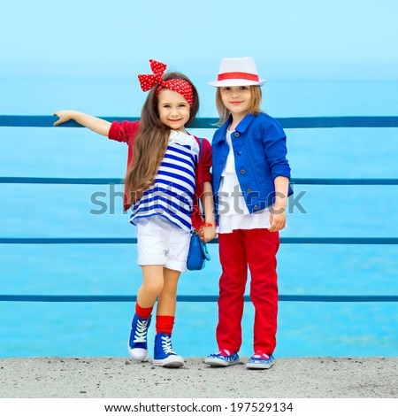 Fashion kids resting on the sea . Vacation, friendship, fashionable concept.