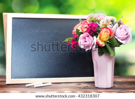 Teacher's day background.Black chalk board frame empty copy space and fresh flowers in vase.Holiday feminine poster.Spring greeting 8 march icon.