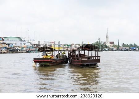 Tien Giang, Vietnam - Nov 28, 2014: Boat filled with fruits, vegetables and other products on sale on Cai Be floating market on Tien river, border between Tien Giang, Vinh Long and Ben Tre Provinces