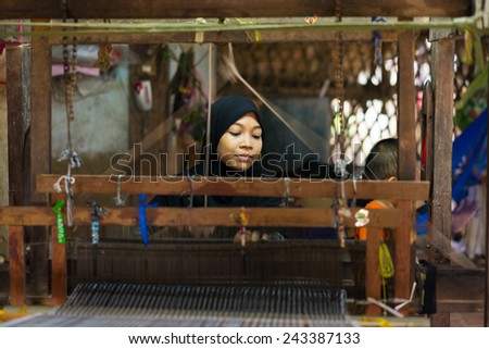An Giang, Vietnam - Nov 29, 2014: Champa woman weaves textile at home at Cham village, Mekong delta, Vietnam