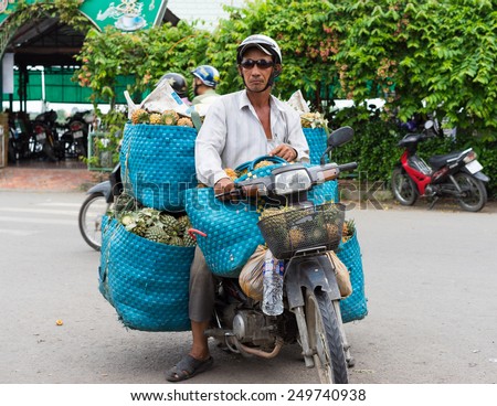 Vinh Long, Vietnam - Nov 30, 2014: Motorbike driver transporting fruits at Vinh Long market, Mekong delta. Transportation by motorbike is the fast, flexible and cheap way in Mekong delta