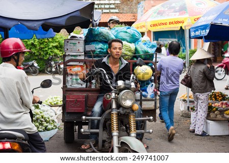 Vinh Long, Vietnam - Nov 30, 2014: Motorbike driver transporting fruits at Vinh Long market, Mekong delta. Transportation by motorbike is the fast, flexible and cheap way in Mekong delta