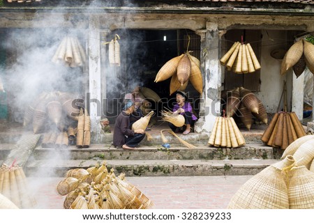 Hung Yen, Vietnam - July 26, 2015: Old women weaves bamboo fish trap at Vietnamese traditional crafts village Thu Sy, Hung Yen province.
