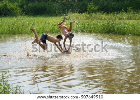 Bac Ninh, Vietnam - May 29, 2016: Children catching fish by fishing bamboo trap - the old traditional way, on pond in Bac Ninh province