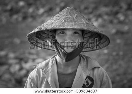 Hanoi, Vietnam - June 12, 2016: Black and white portrait of woman farmer wearing conical hat in Son Tay provincial town