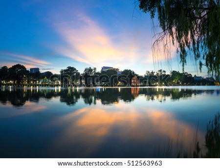 Hoan Kiem lake ( Ho Guom, Sword lake), the center of Hanoi capital, Vietnam at twilight. Willow branches on foreground