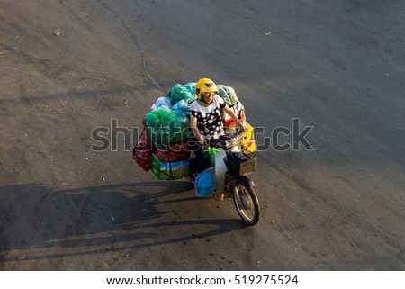 Hanoi, Vietnam - July 23, 2016: Aerial view of Vietnamese woman transporting fruit by motorcycle on Yen Phu street in early morning
