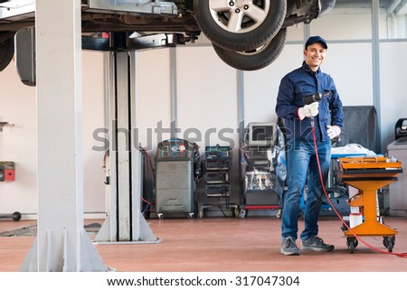 Portrait of a mechanic repairing a car in his garage