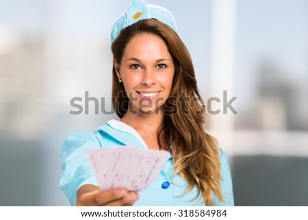Portrait of a smiling stewardess holding tickets
