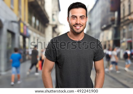 Young male fashion model walking in street