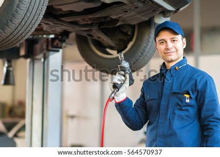 Portrait of a mechanic replacing a wheel