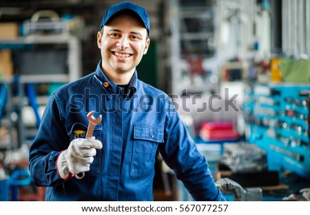 Auto mechanic smiling in his garage
