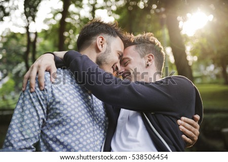In garden Happy gay couple holding their child In garden Happy gay couple holding their child