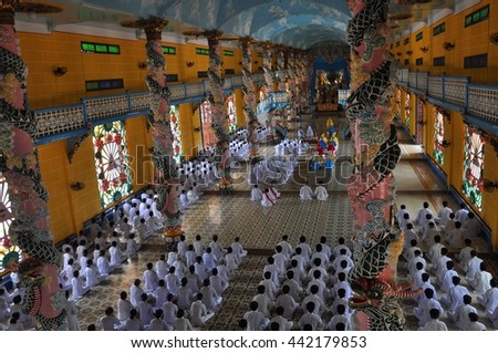 TAY NINH, VIETNAM - JUNE, 16, 2015: People praying in a Caodai temple in Vietnam