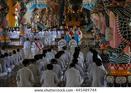 TAY NINH, VIETNAM - JUNE, 16, 2015: People praying in a Caodai temple in Vietnam