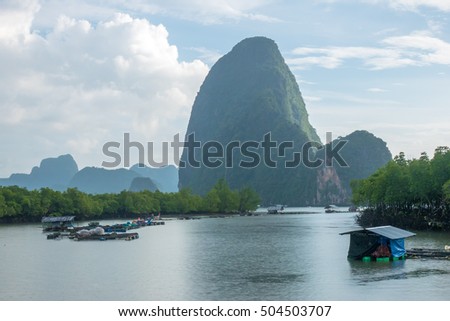 Fisherman float house in lake and big mountain at thailand