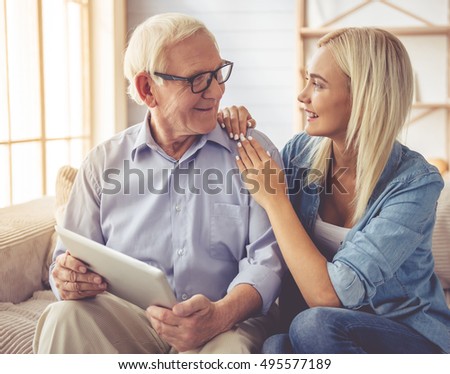 https://thumb1.shutterstock.com/display_pic_with_logo/2181548/495577189/stock-photo-handsome-old-man-and-beautiful-young-girl-are-using-a-digital-tablet-talking-and-smiling-while-495577189.jpg