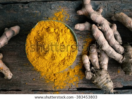Turmeric powder and turmeric on wooden background .- Vintage Filter Processing.