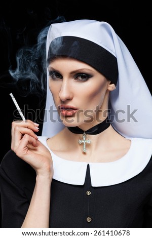 nun girl in the studio. Spoiled concept of religion. Cigarette ...