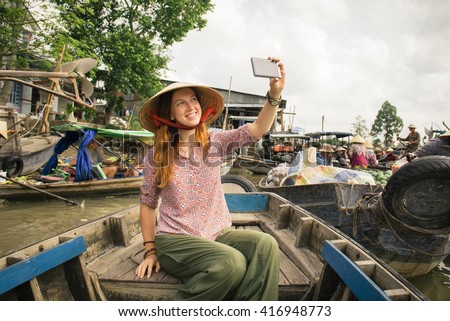 Woman tourist take selfie photo from the boat on Cai Rang floating market, Can Tho, Vietnam